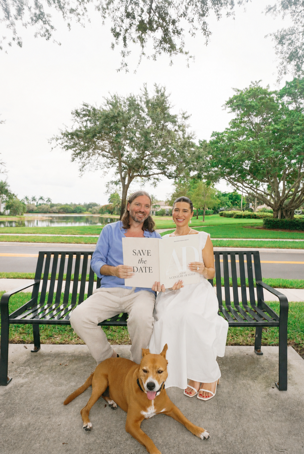Patrick and Sarah holding a save the date sign with their dog